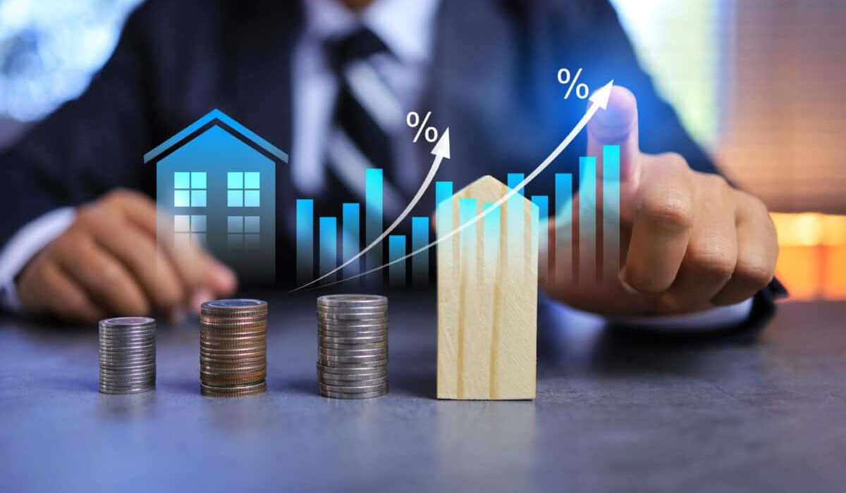 Real estate investment concept with person pointing on growth graph and coin stacking to get profit from property