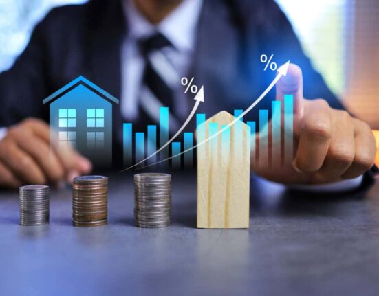 Real estate investment concept with person pointing on growth graph and coin stacking to get profit from property