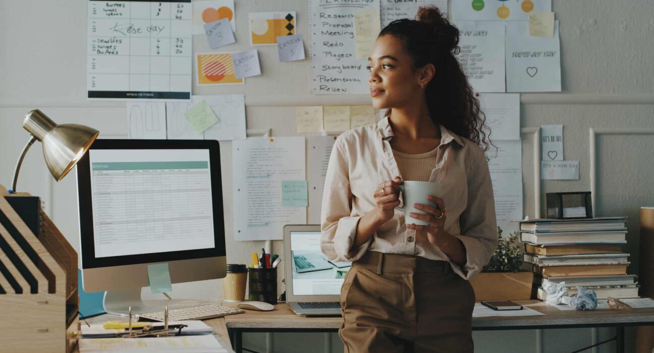 A worker drinks out of a mug in an office.