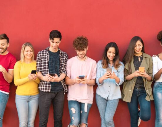 young people stare at smartphones