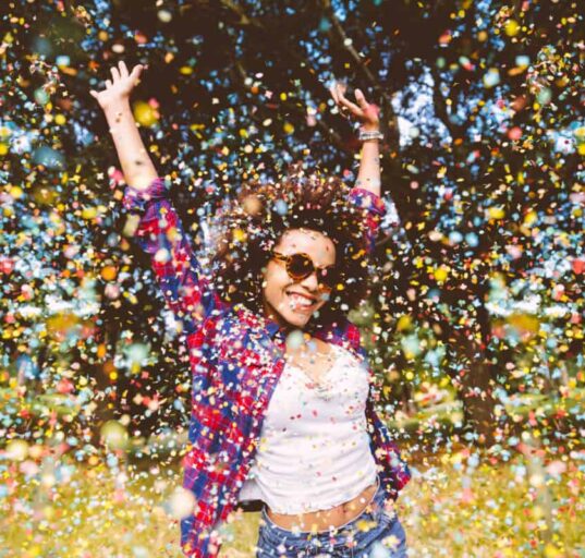 person enjoys shower of confetti outside