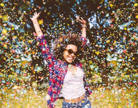 person enjoys shower of confetti outside
