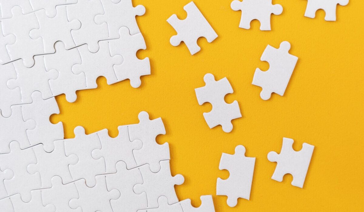 Partially complete jigsaw puzzle with scattered missing pieces