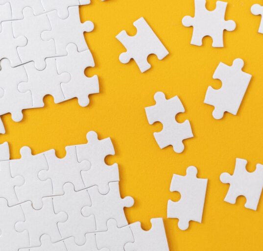 Partially complete jigsaw puzzle with scattered missing pieces