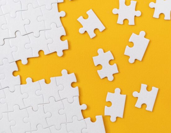 Partially complete jigsaw puzzle with scattered missing pieces