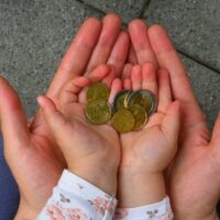 holding coins in hand for the future