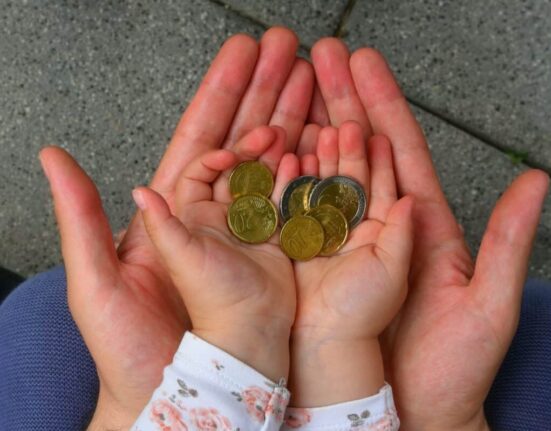 holding coins in hand for the future